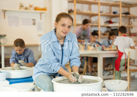 Girl working at a potter's wheel 132282696