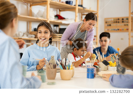 Preteen girl speaking to a circle member while processing ceramic items Preteen girl speaking to a circle member while processing ceramic items 132282700