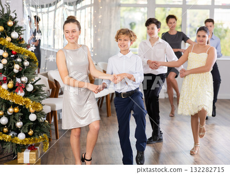 Teen boy and girl dancing modern discofox in couple during lesson at studio in New Year atmosphere Teen boy and girl dancing modern discofox in couple during lesson at studio in New Year atmosphere 132282715