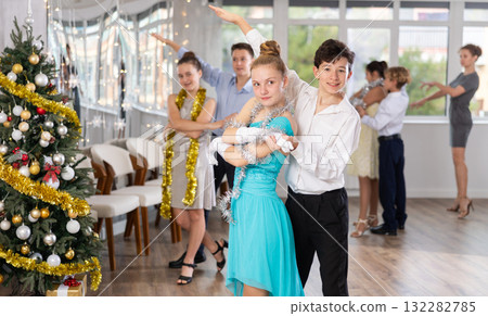 Teenagers in holiday clothes dancing swing dance near Christmas tree 132282785