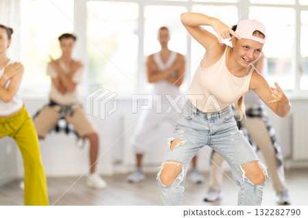 Girl in baseball cap with two hair pigtails with group of teenage friends, learn to dance hip hop 132282790