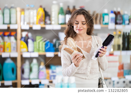 Young woman choosing hairbrush in store 132282805