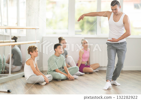 Teen visitors to choreographic class, observe professional rendering of dance performances couch 132282922