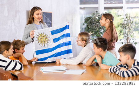 Teacher showing Uruguay flag to group of schoolchildren Teacher showing Uruguay flag to group of schoolchildren 132282982