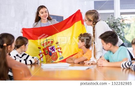 Teacher showing Spain flag to group of schoolchildren Teacher showing Spain flag to group of schoolchildren 132282985