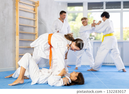 Group of children in kimono practicing karate in a sports gym. Martial arts training session 132283017