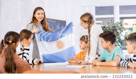 Teacher showing Argentina flag to group of schoolchildren Teacher showing Argentina flag to group of schoolchildren 132283022