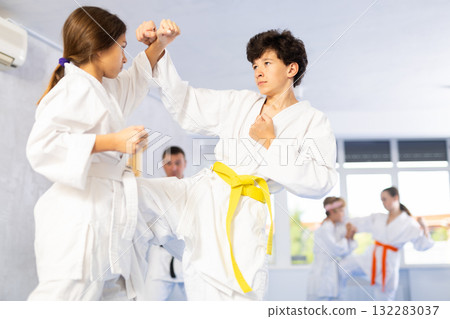 Boy and girl training karate techniques in studio 132283037