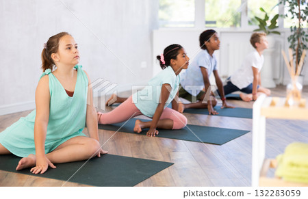 Preteen Children practicing yoga in Urdhva Mukha Shvanasana in gym Preteen Children practicing yoga in Urdhva Mukha Shvanasana in gym 132283059