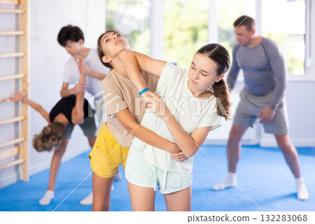 Boy and girl train to perform works out blow to jaw at opponent, while learning self-defense Boy and girl train to perform works out blow to jaw at opponent, while learning self-defense 132283068