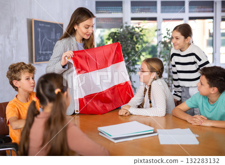 Teacher showing Austria flag to group of preteen schoolchildren Teacher showing Austria flag to group of preteen schoolchildren 132283132