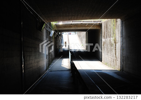 People walking through a narrow tunnel People walking through a narrow tunnel 132283217