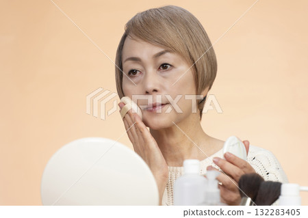 Senior woman putting on makeup 132283405