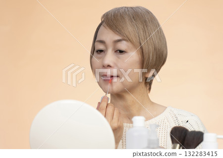 Senior woman putting on makeup 132283415
