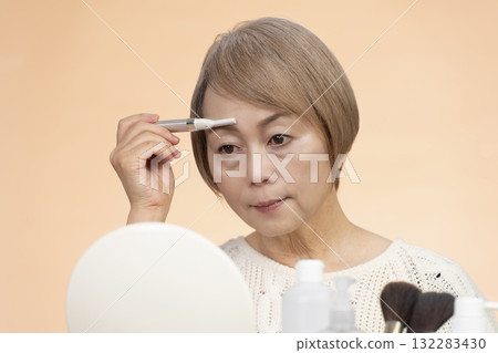 Senior woman putting on makeup 132283430