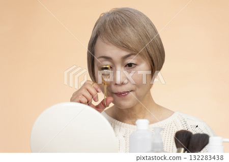 Senior woman putting on makeup 132283438
