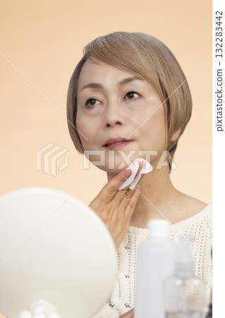 Senior woman putting on makeup Senior woman putting on makeup 132283442