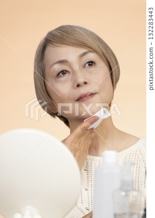 Senior woman putting on makeup Senior woman putting on makeup 132283443