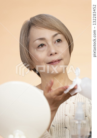 Senior woman putting on makeup 132283452