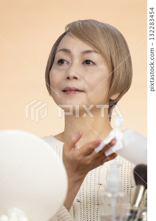 Senior woman putting on makeup 132283454