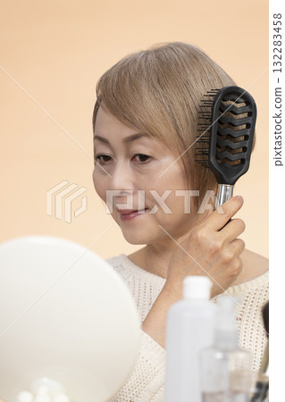 Senior woman putting on makeup Senior woman putting on makeup 132283458