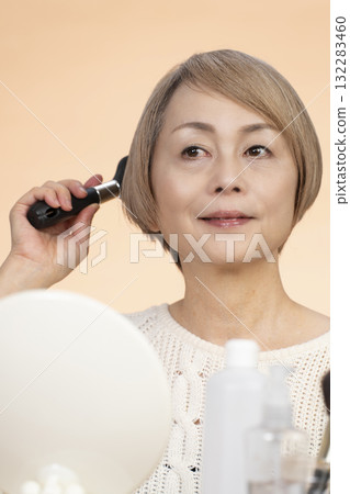 Senior woman putting on makeup 132283460