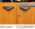 Handyman fixing uneven cabinet door hinge in kitchen 132284989