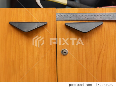 Handyman fixing uneven cabinet door hinge in kitchen Handyman fixing uneven cabinet door hinge in kitchen 132284989