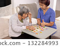 Nurse in nursing home helping a senior woman with number puzzle.  . Dementia, Alzheimer's disease concept 132284993