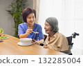 Caregiver feeding elderly asian woman with soup. 132285004