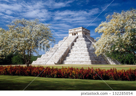 Ancient Mayan Ruins of Chichen Itza with Pyramid Temple Surrounded by Clear Sky and Lush Greenery in Mexico 132285054