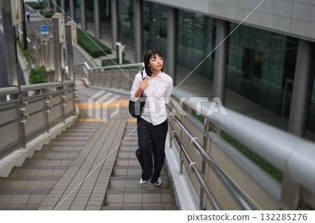 Businesswoman climbing stairs of pedestrian bridge Businesswoman climbing stairs of pedestrian bridge 132285276