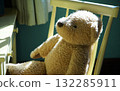 A teddy bear on a chair in a sunny room 132285911