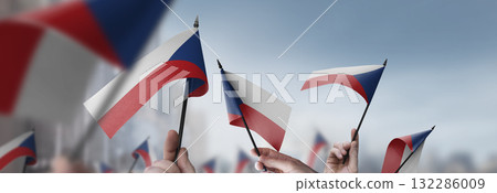 Czechia flags in their hands on a blurred urban background 132286009