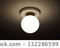 Round light fixture on the ceiling of the room 132286599