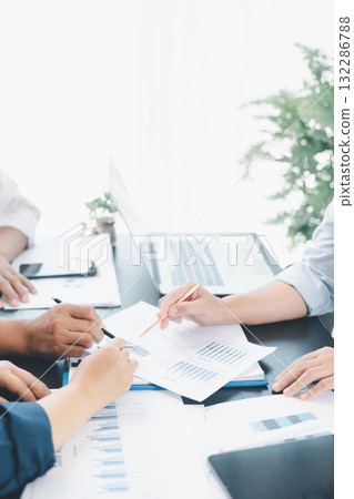 Business teamwork reviewing financial report with charts and graphs in modern office, colleagues discussing analysis, planning strategy, growth and corporate success with documents and technology. 132286788