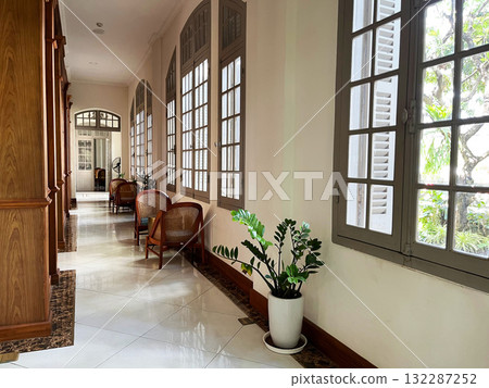 Elegant hallway with classic wooden furniture, large arched windows, and soft ambient lighting, creating a warm and inviting atmosphere, Classic hallway with wooden furniture, arched windows, and warm Elegant hallway with classic wooden furniture, large arched windows, and soft ambient lighting, creating a warm and inviting atmosphere, Classic hallway with wooden furniture, arched windows, and warm 132287252