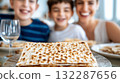 Family enjoying passover with traditional matzo bread on dining table 132287656