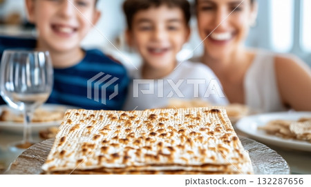 Family enjoying passover with traditional matzo bread on dining table 132287656