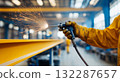 Industrial worker with protective gear using grinding tool in factory workshop 132287657
