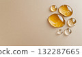 Honey-colored liquid droplets on beige surface with bubbles highlighting fluid texture 132287665