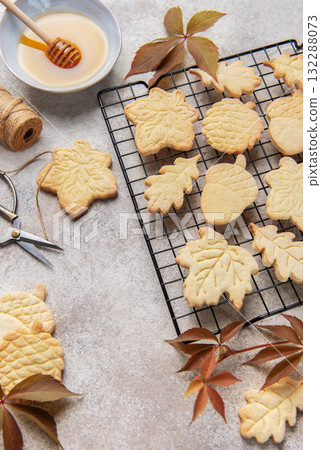 Autumn cookies on wire rack with honey and leaves 132288073
