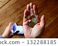 An elderly woman's hand holding coins, image of savings and retirement funds 132288185