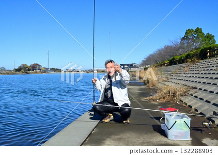 An angler fishing in the Hinuma River below Oarai Station 132288903
