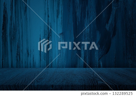 Wooden Table with Spotlight on Dark Blue Grunge Wall Background 132289525
