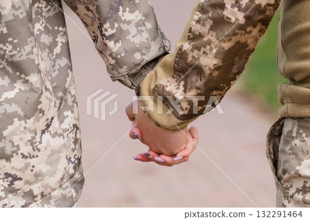 U.S. Army Soldiers Holding Hands, Camouflage Uniforms, Outdoor Scene, Support, Connection, Brown and Green Tones, Military Lifestyle. 132291464