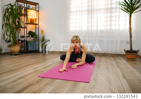 Stretching and balancing in a bright indoor yoga studio space 132291541