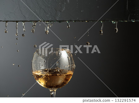 White wine flows down into a glass. White wine flows down into a glass. 132291574