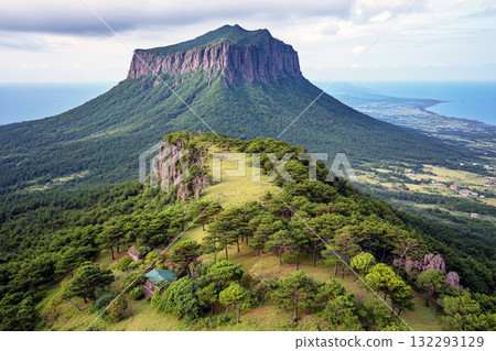 Majestic Mesa with Flat Top and Steep Cliffs Surrounded by Lush Green Valleys under Dramatic Sky Majestic Mesa with Flat Top and Steep Cliffs Surrounded by Lush Green Valleys under Dramatic Sky 132293129