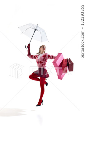 Fashion woman in pink heart sweater jumping with umbrella and shopping bags in air Fashion woman in pink heart sweater jumping with umbrella and shopping bags in air 132293855